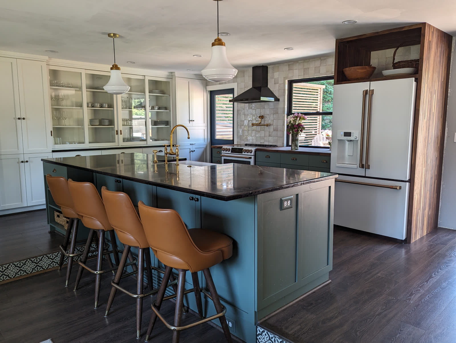Custom kitchen with teal island, leathered black granite counter and brass bridge faucet
