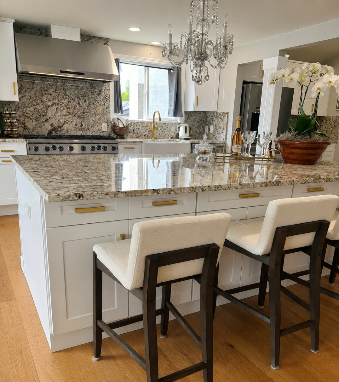 Custom kitchen with granite backsplash, gas range and crystal chandelier