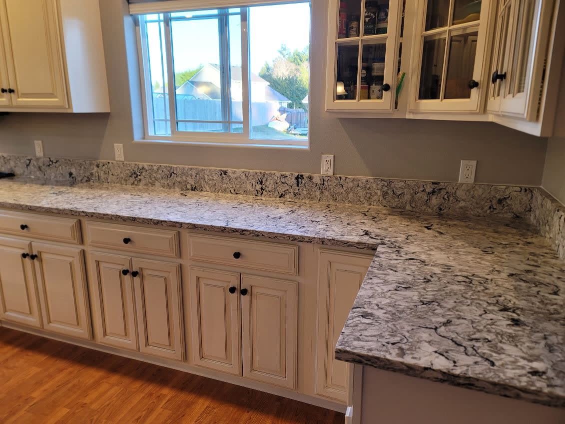 Bold black-and-white swirl granite countertop with glazed cabinetry