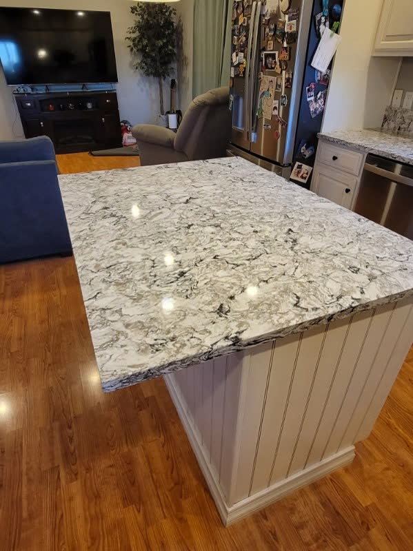 Dramatic veined quartz kitchen island in an open living space