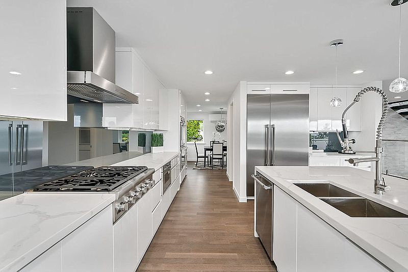Contemporary white kitchen with calacatta waterfall counters and hardwood floors