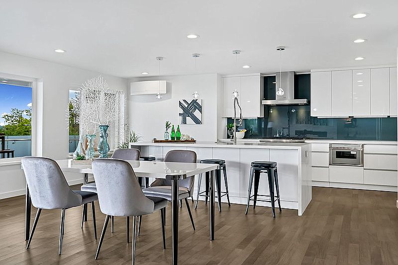 Open kitchen and dining area with white cabinetry and dark glass backsplash