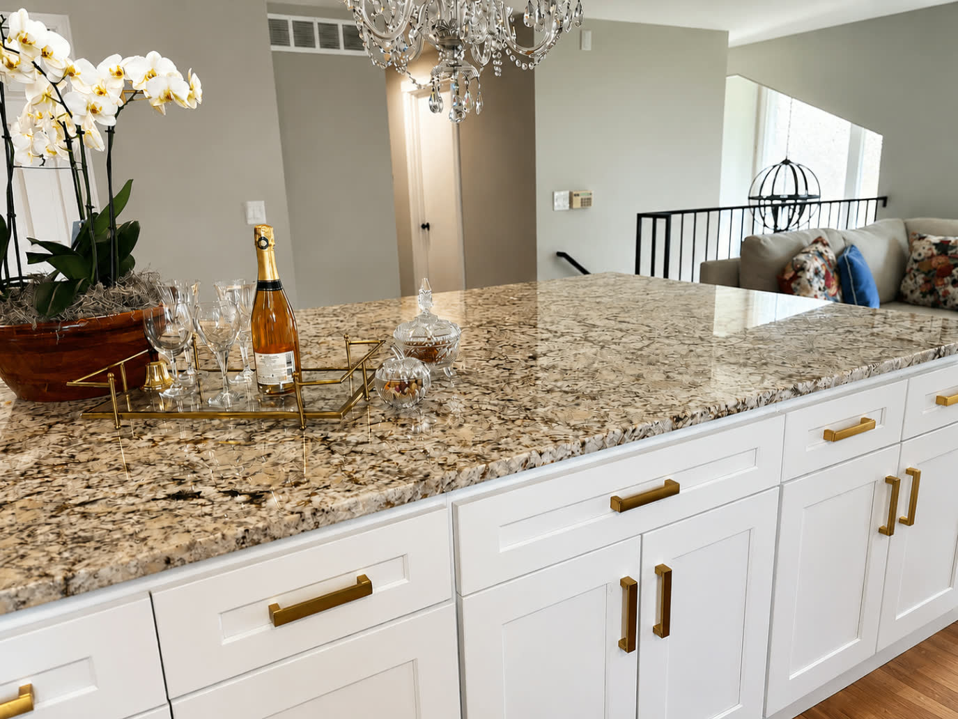 Close-up of polished granite island with gold hardware and white cabinetry