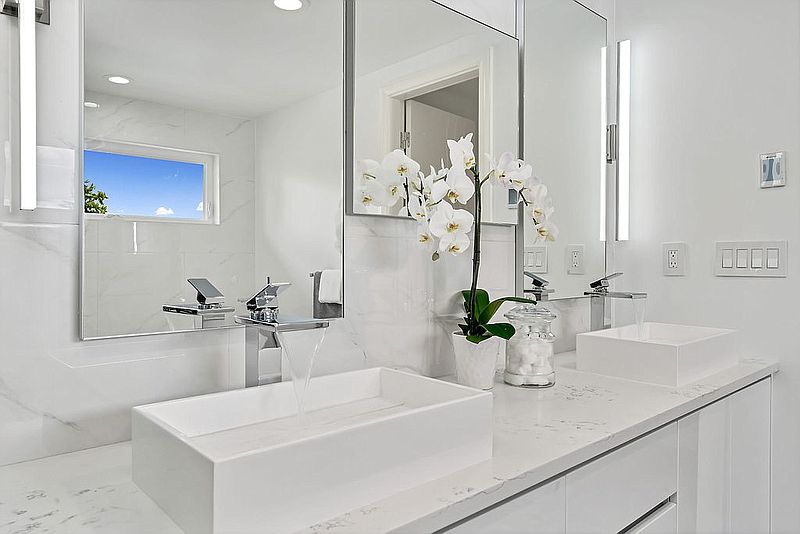 Marble-topped double vanity with vessel sinks and polished chrome faucets