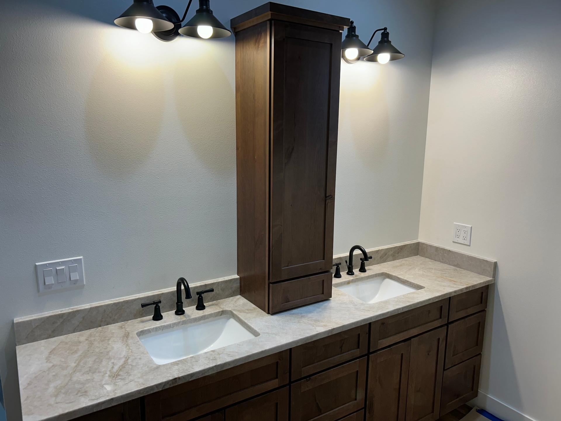 Rustic double vanity with taj mahal quartzite counter, dark wood cabinets and matte black fixtures