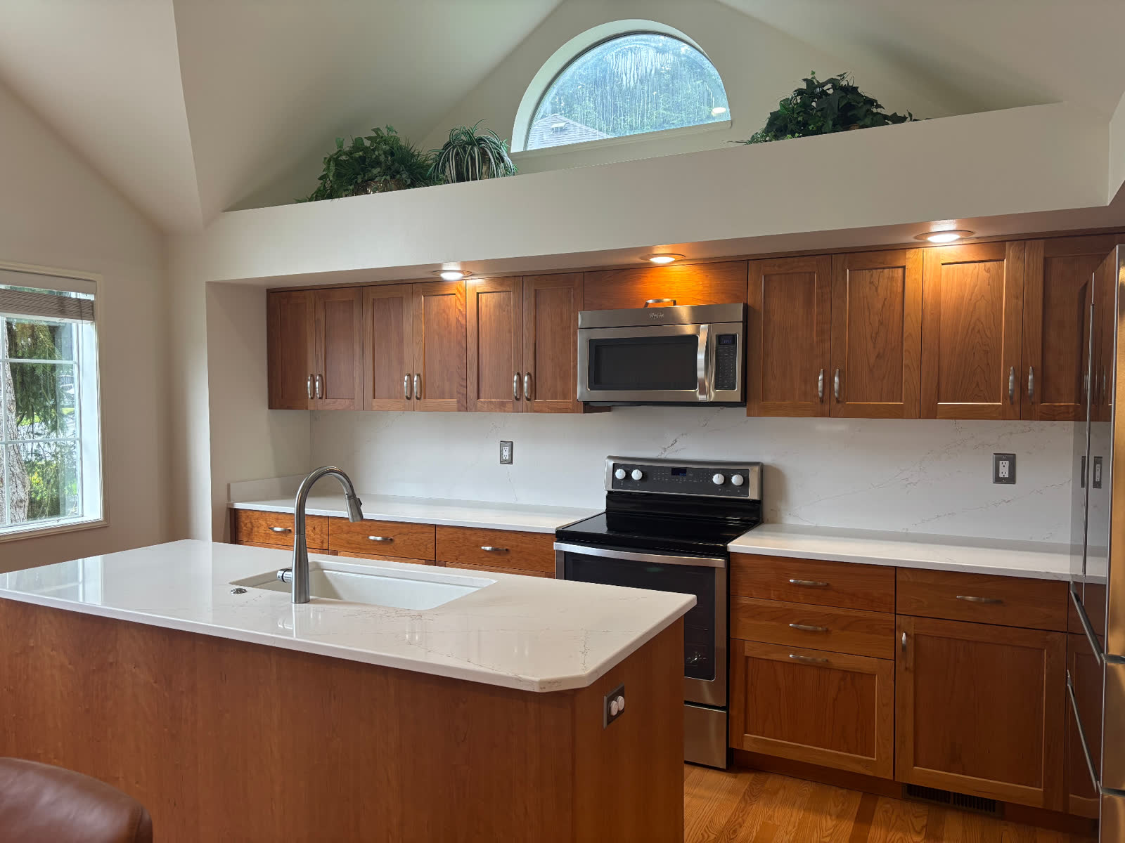 Traditional cherry-wood kitchen with white quartz island and veined backsplash