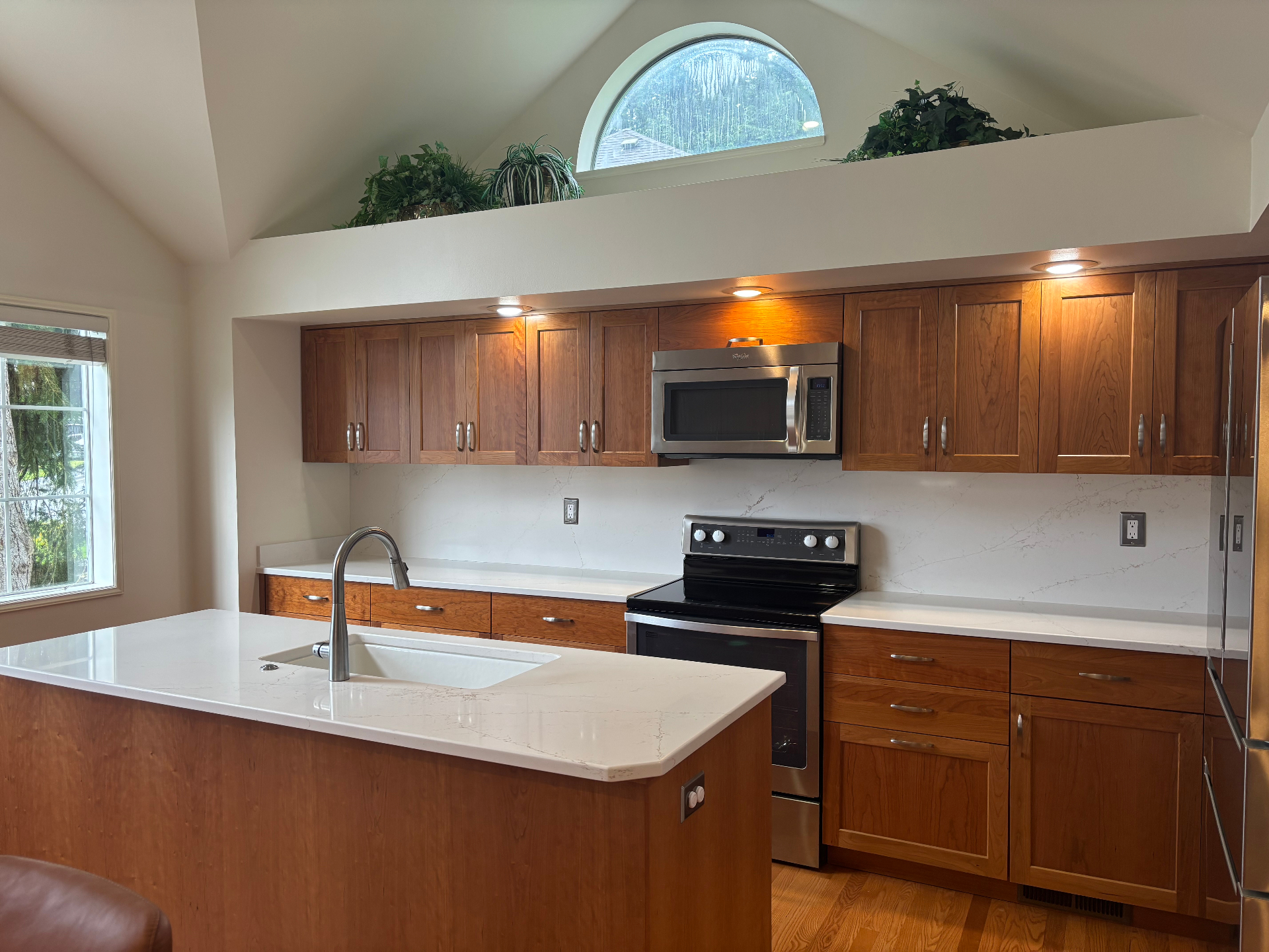 Traditional cherry-wood kitchen with white quartz island and veined backsplash