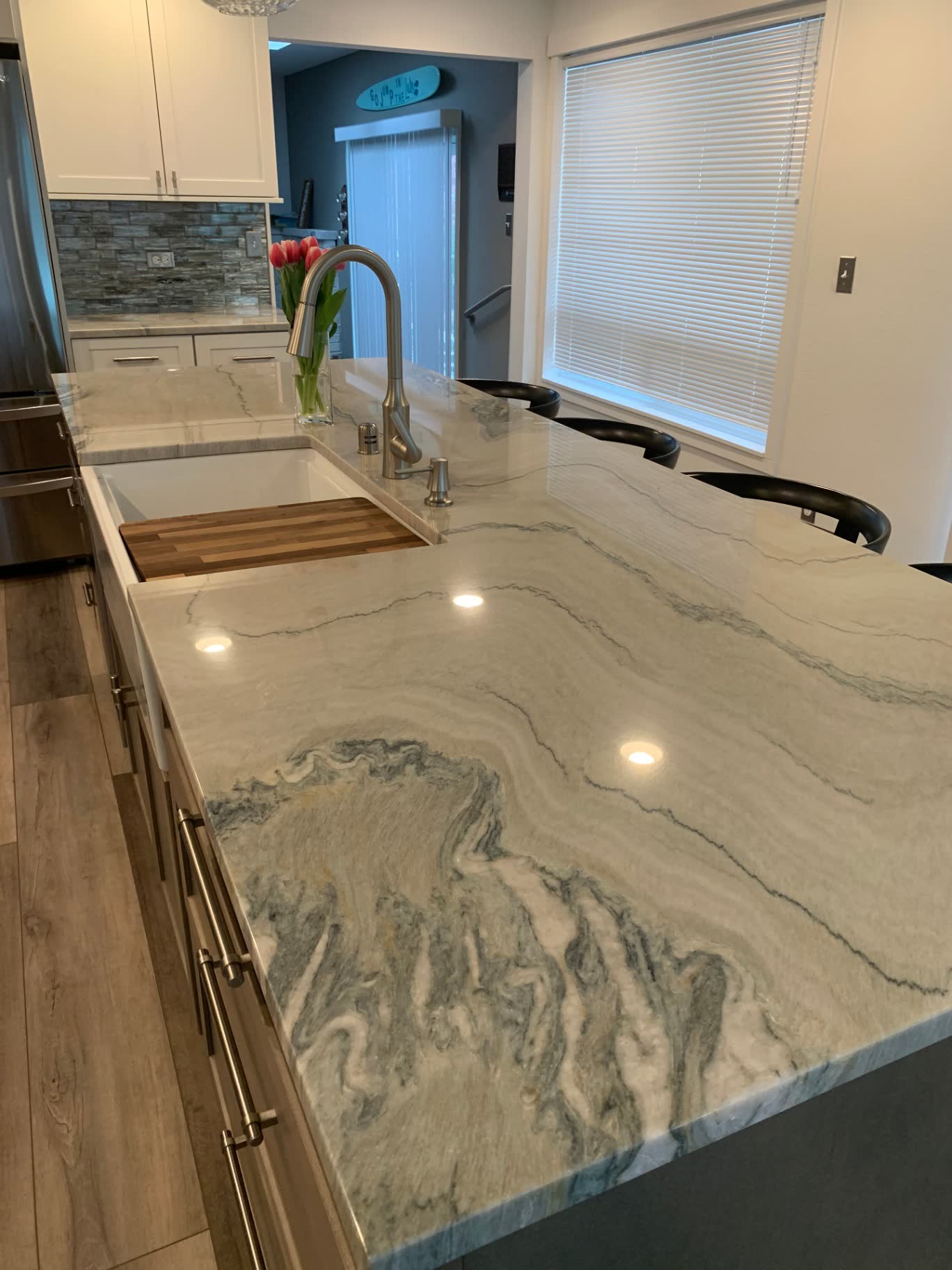 Close-up of dramatic swirled quartzite island with undermount sink and stainless faucet