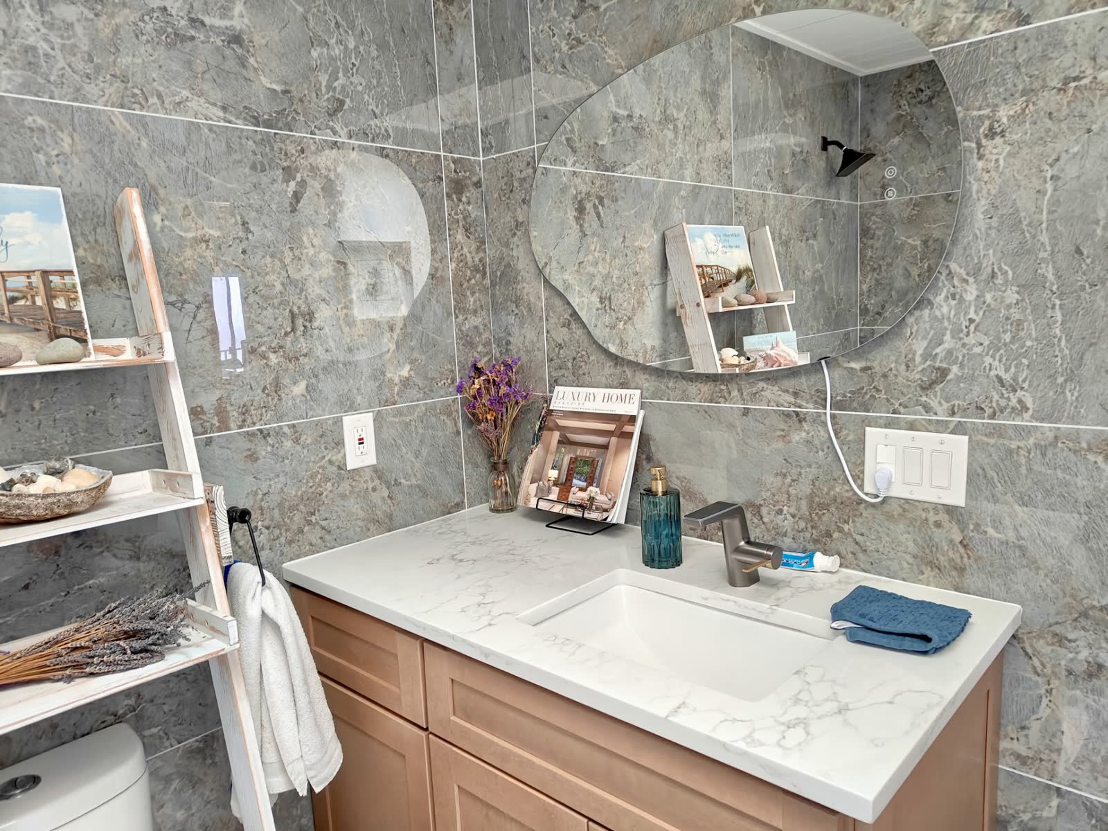 Modern bathroom vanity with marble-look quartz top and dramatic stone wall tile