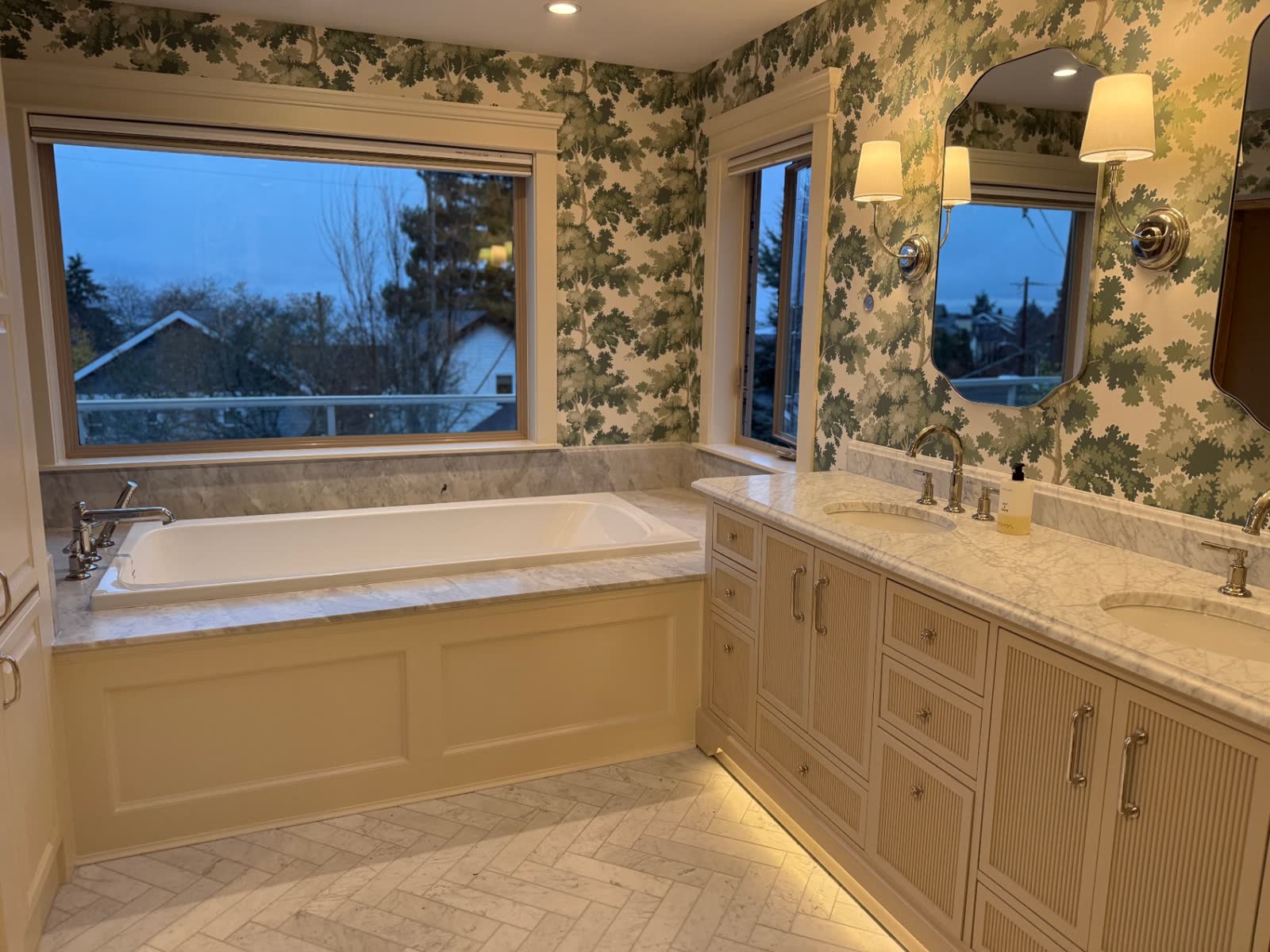 Traditional primary bath with soaking tub, marble surround and botanical wallpaper