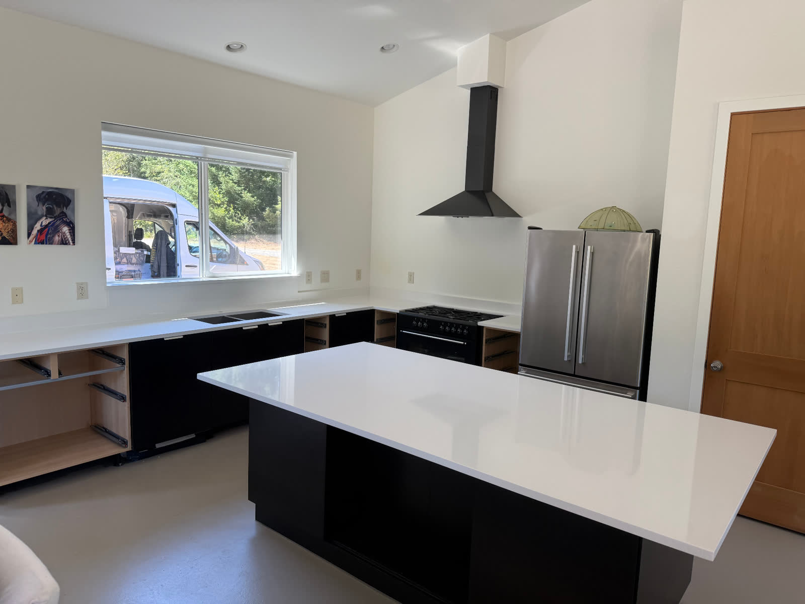 Modern black kitchen with white quartz waterfall island and vaulted ceiling