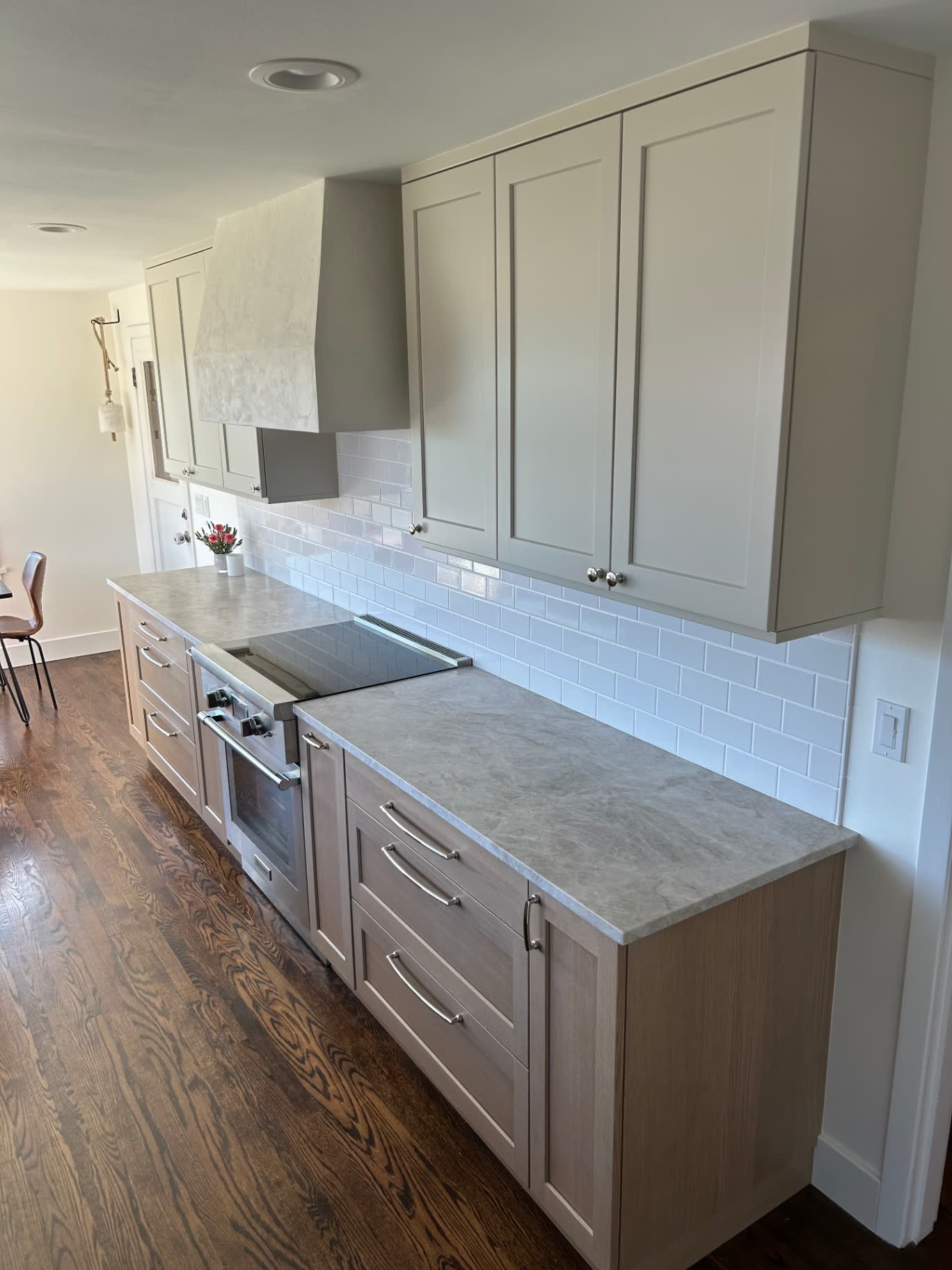 Galley kitchen with white oak cabinets, quartzite counters and plaster hood