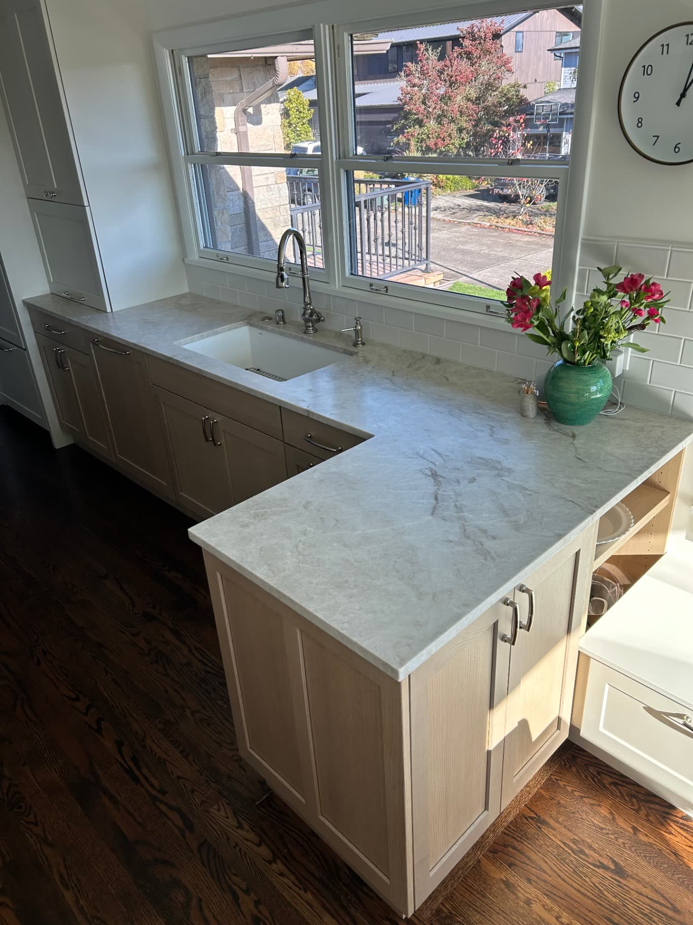 Corner kitchen peninsula with quartzite counters, apron sink and oak cabinets