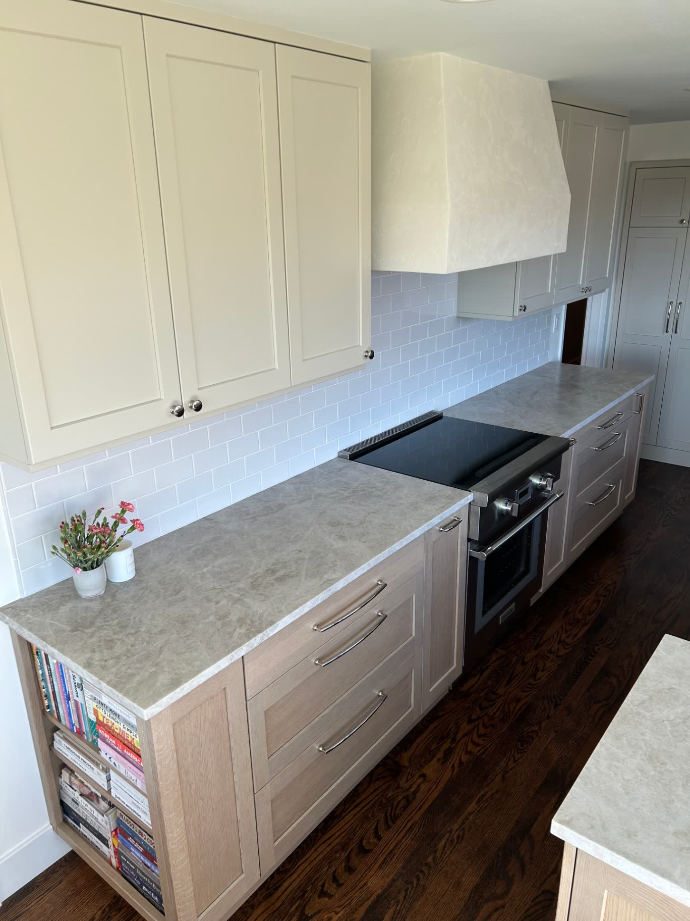 Oak kitchen with quartzite counters, subway tile and integrated cooktop