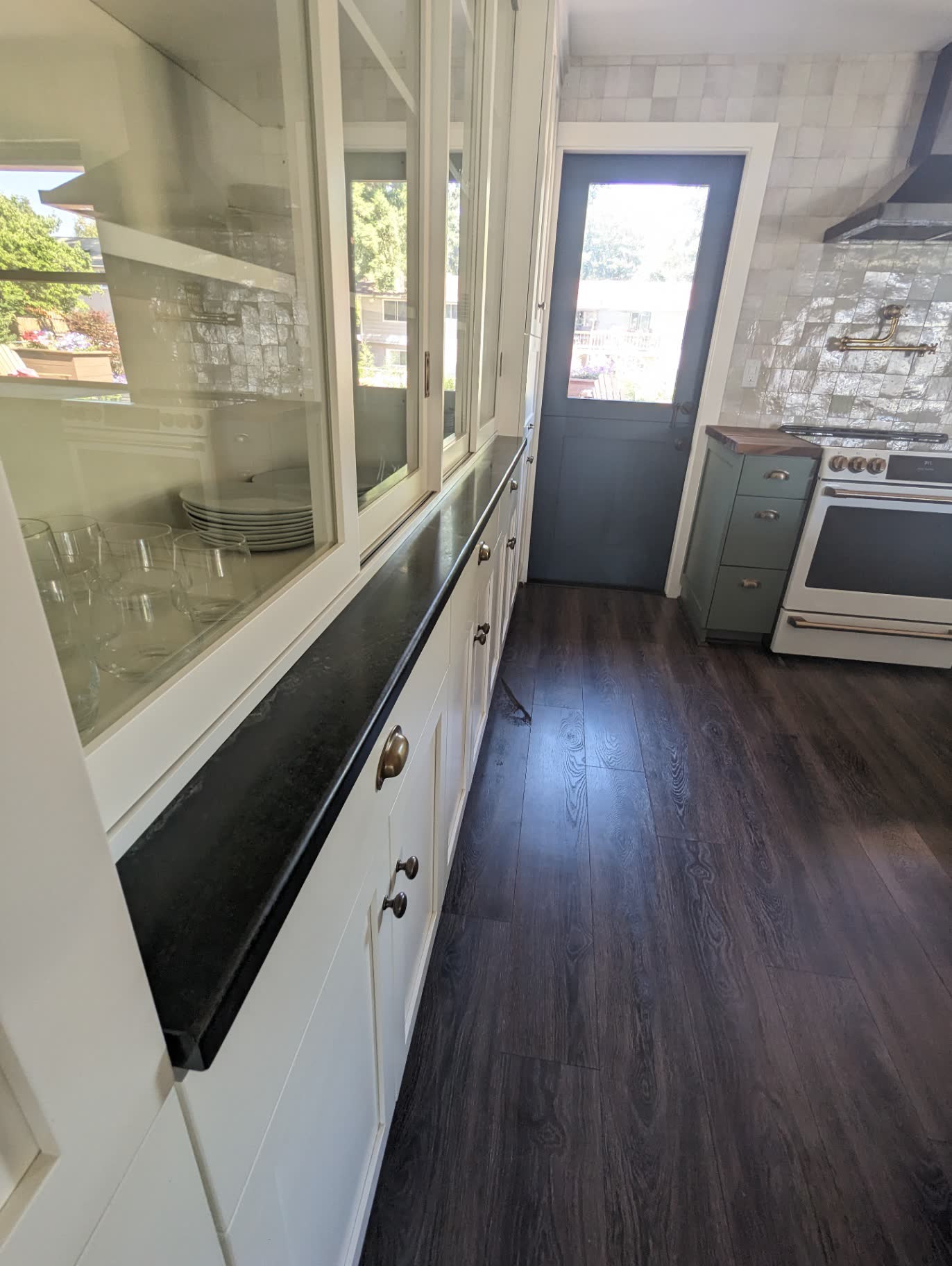 White glass-front hutch with soapstone counters and zellige tile range wall
